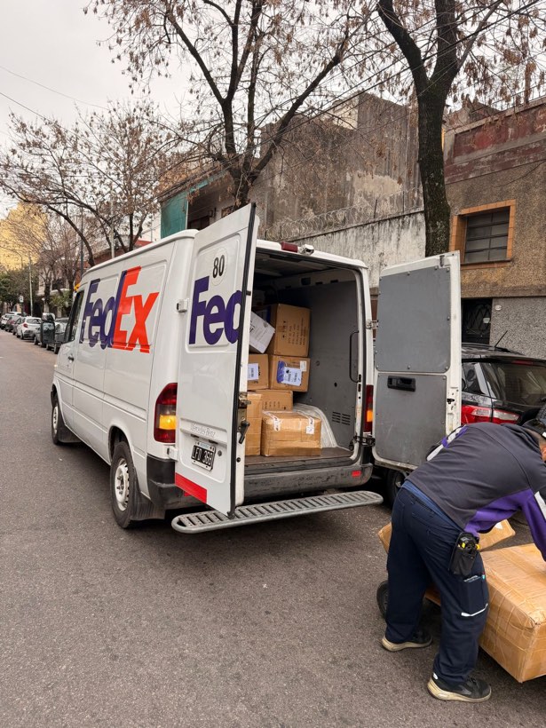 Camioneta de correo descargando cajas en la puerta del depósito